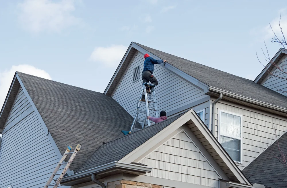 Professional roof repair with ladder at a home in New Castle County, Delaware